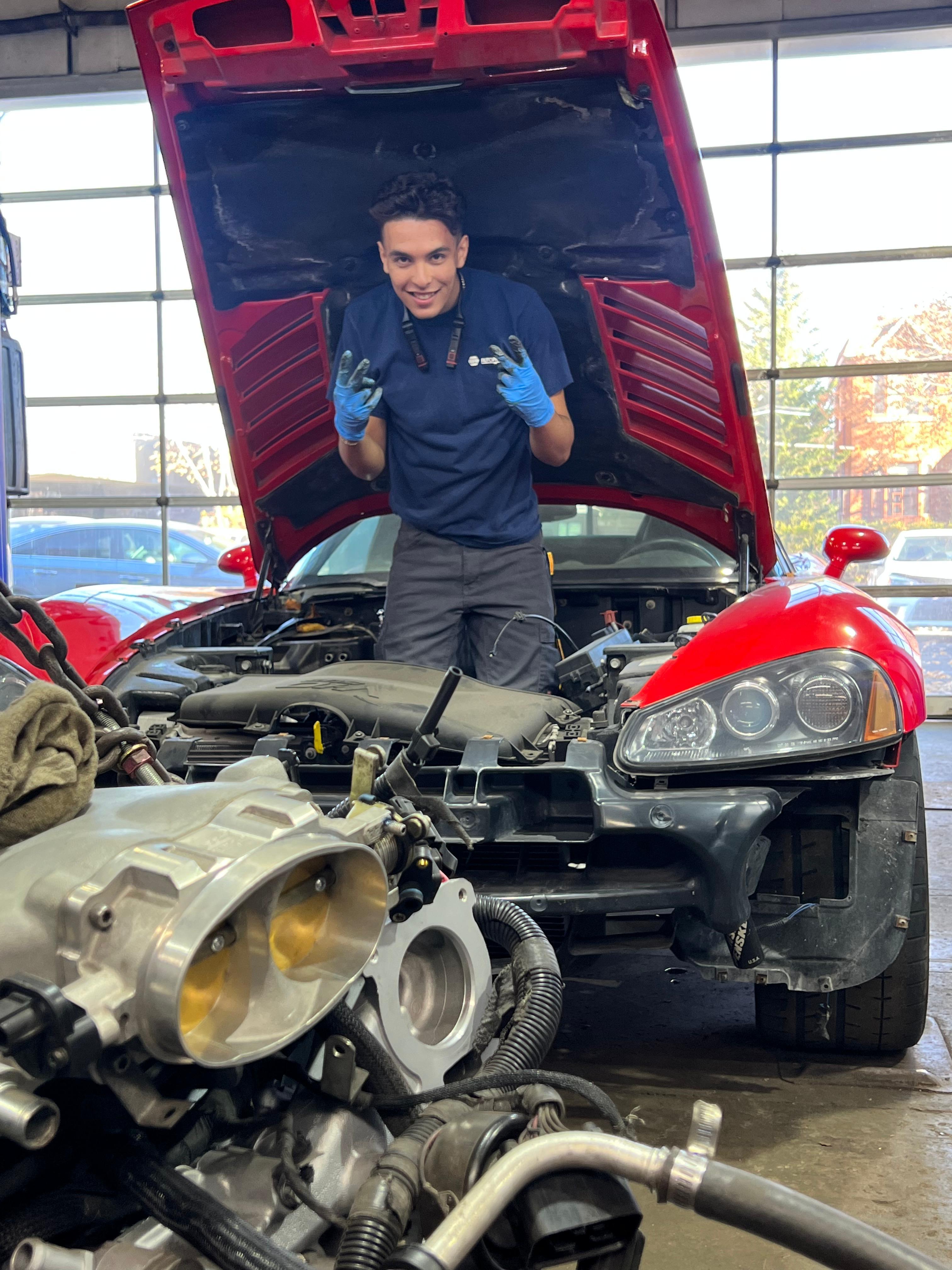 Mehdi réparant une voiture rouge